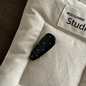 Nahaufnahme einer französischen Haarspange in Schwarz mit weißen Punkten auf Stoff