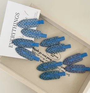 Detailed view of blue denim pattern hair clips with colorful polka dots on fabric