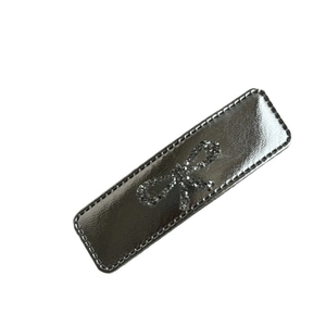 Silver leather bow hair clip with sparkling rhinestones and elegant stitching detail