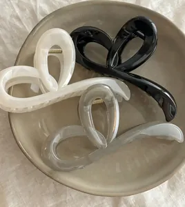 Détail de trois pinces à cheveux papillon en noir crème et gris sur une assiette