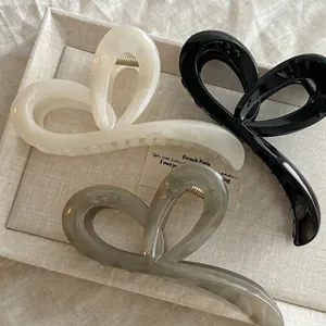 Trois élégantes pinces à cheveux en forme de nœud en crème, noir et gris marbré