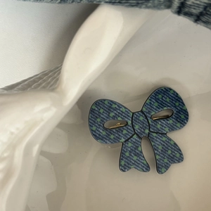 Fermaglio per capelli con fiocco in denim a pois su piatto di ceramica bianca