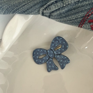 Fermaglio per capelli con fiocco in denim a pois su un vassoio di porcellana bianca