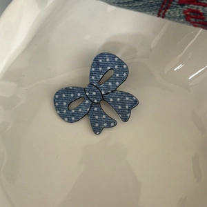 Dettaglio ravvicinato di un fermaglio per capelli a pois in denim in una ciotola