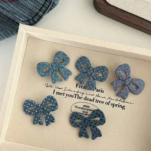 Set di cinque fermagli per capelli a fiocco in denim con pois colorati su un vassoio