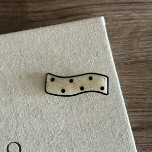 Elegant wavy cream hair clip with black polka dots and textured finish for women