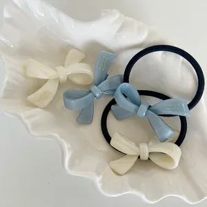 Blue and cream acetate bow hair clips and ties set in a shell ceramic tray