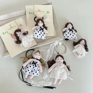 Dettaglio di accessori per capelli bambola sirena fatti a mano con pois e pizzo su carta