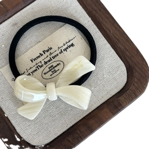 Elegant cream white marble bow hair tie with high elastic band on a rustic display