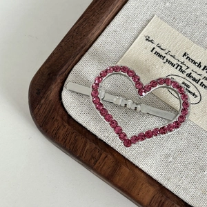 Nahaufnahme der herzförmigen magnetischen Haarspange mit rosa Strass und Silber-Finish