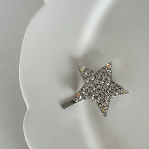 Eleganter silberner Stern-Haarclip mit Zirkon-Strass auf weißem Keramikteller