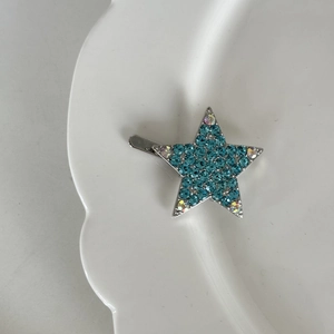 Detail der silbernen Stern-Haarklammer mit glitzernden blauen Strasssteinen und Zirkon