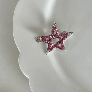 Nahaufnahme einer silbernen Stern-Magnet-Haarklammer mit funkelnden rosa Strasssteinen