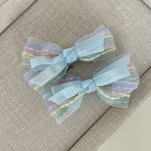 Set di due fermagli per capelli in tulle azzurro con motivi colorati a onde arcobaleno