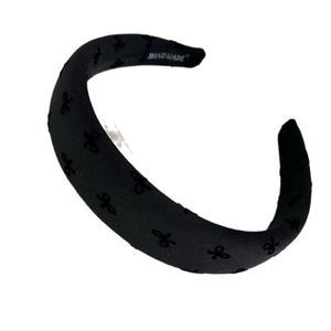 Padded black headband with ribbed fabric and embroidered bows for a voluminous hair look