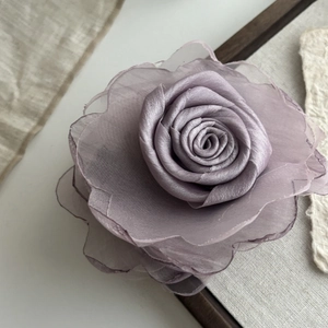 Close-up of elegant lavender mesh rose flower hair clip with layered soft fabric petals