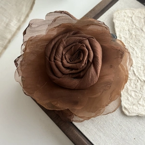 Vintage mesh rose hair claw clip in deep brown chiffon on a rustic wooden background