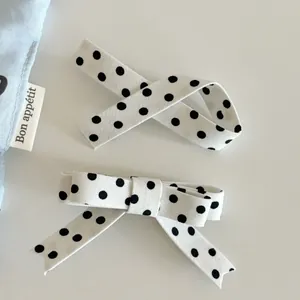 Detailed view of polka dot bow hair clips set with ribbon fabric and alligator clip base