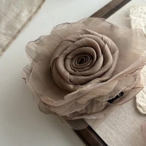 Close-up of elegant mesh rose hair clip showing delicate fabric petals and texture