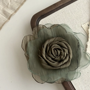 Close-up of olive green mesh rose hair claw with delicate pleated chiffon petal texture