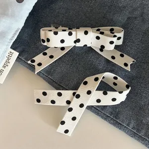 Polka dot bow hair clip set and matching ribbon on a denim background for women