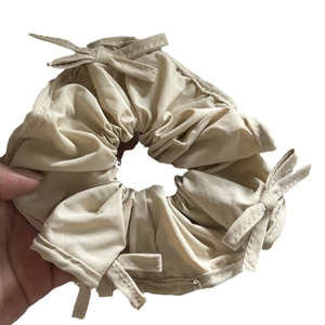 Beige French satin scrunchie with cute bow accents and premium twill fabric texture