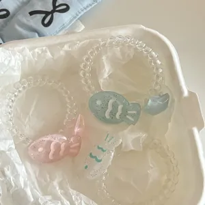 Nahaufnahme von drei Spiral-Haargummis mit niedlichen Fisch-Anhängern in Rosa und Blau