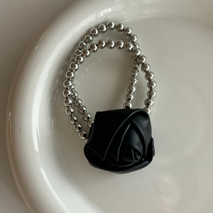 Bracelet élastique chic perlé argent avec rose noire 3D détaillée sur plateau blanc