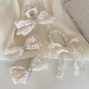 Dettaglio di fermagli per capelli in pizzo e elastico di perle con cuori d'argento