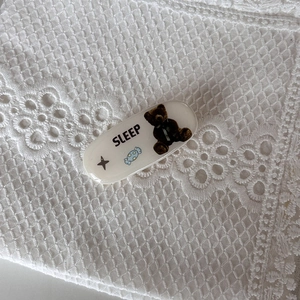 Graziosa clip per capelli ovale bianca con orsetto e testo SLEEP su pizzo bianco
