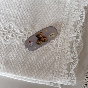 Fermaglio per capelli ovale grigio con orsetto e cupcake su sfondo di pizzo vintage