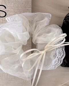 Dettaglio ravvicinato dell'elastico in organza bianca con pizzo e nastri sottili