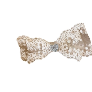 Elegante fermaglio per capelli in pizzo bianco con diamante a cuore su sfondo bianco