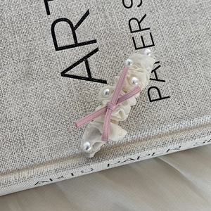 Sweet ribbon bow hair clip with lace and pearls on an aesthetic vintage book background