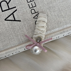 Detailed shot of mesh hair clip with pink ribbon bow and vintage pearl accent