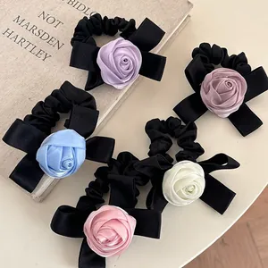 Détails de cinq chouchous en satin avec fleurs de rose colorées sur fond vintage chic