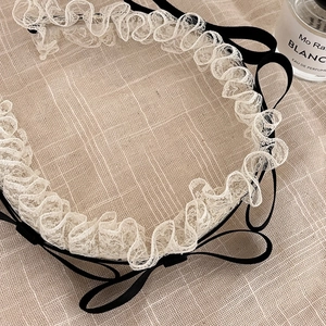 Serre-tête en dentelle vintage avec nœuds en ruban noir sur fond de coton beige