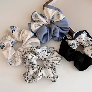 Détail de l'ensemble de 4 chouchous en satin avec imprimés papillon et calligraphie