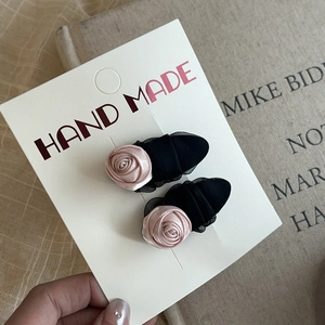 Pink rose hair clips set with black mesh detail on handmade paper display card