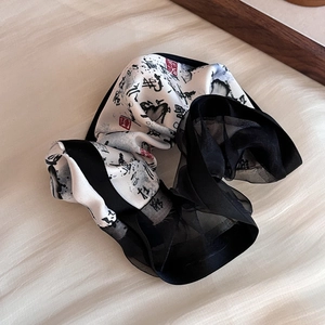 Détail d'un chouchou en satin avec calligraphie chinoise et texture en organza noir