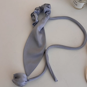 Dettaglio dell'elastico per capelli a tulipano blu polvere con lunghi nastri di seta