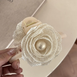 Detailed view of elegant cream lace rose hair claw clip with a large pearl center