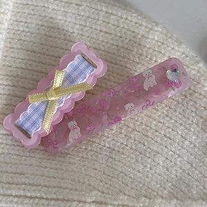 Niedliches Set aus rosa Blumen-Haarspangen mit Katzenmuster auf Strickhintergrund
