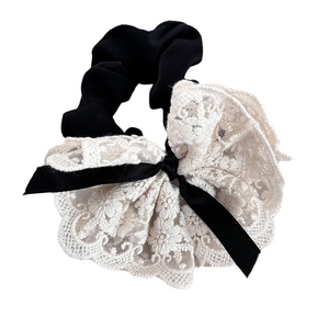 Lace scrunchie with large white flower and black ribbon on a white background
