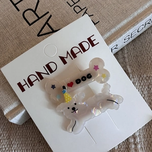 Détail de deux pinces à cheveux en acrylique pour chien avec texte I Love Dog et chapeau