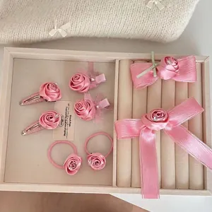 Set de pinzas para el cabello con flores de rosa satinadas y lazos en bandeja