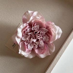Detailed macro view of layered pink silk peony flower hair clip with realistic petals