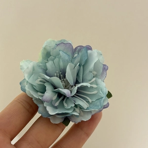 Macro view of blue gradient fabric peony hair clip showing petal texture and size detail