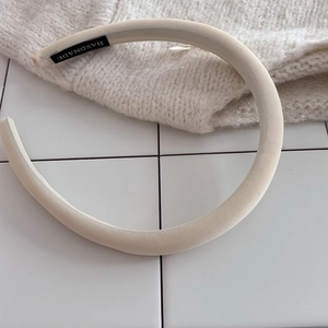 Detail of beige sponge headband with handmade label and high-quality twill fabric texture