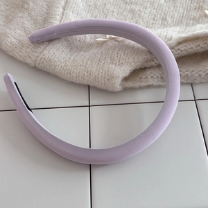 Detail shot of a lilac padded sponge headband with soft twill fabric on a knit backdrop